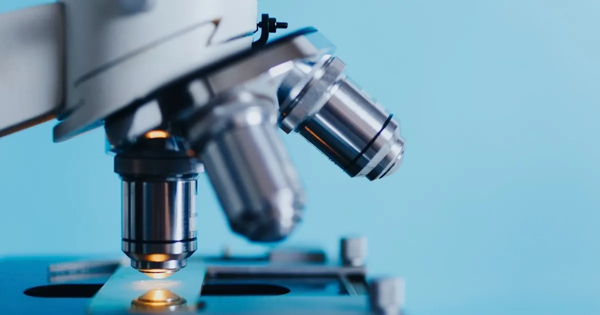 Laboratory microscope with objective lenses over a slide