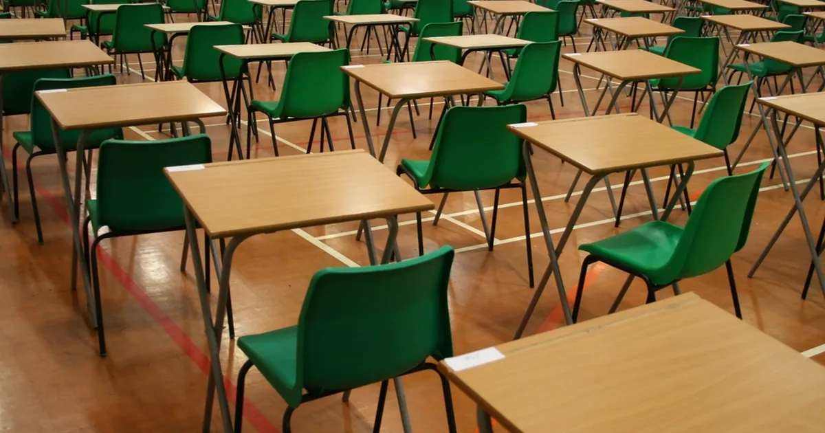 Empty exam hall with rows of desks and chairs